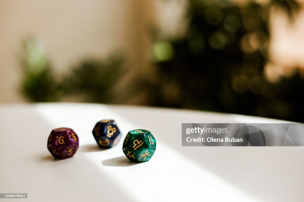 Coloured divination dice on white table.