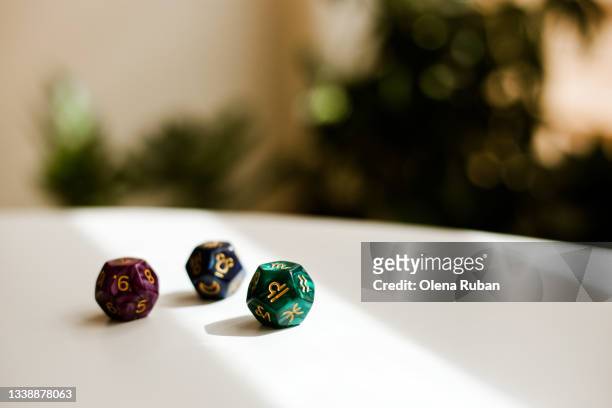 coloured divination dice on white table. - fortune teller table stock pictures, royalty-free photos & images