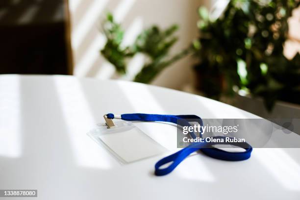 id tag card with blue ribbon on white table. - namensschild stock-fotos und bilder