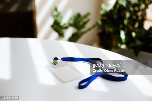 id tag card with blue ribbon on white table. - id card stockfoto's en -beelden