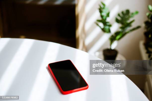 mobile phone on white table. - smartphone table stockfoto's en -beelden