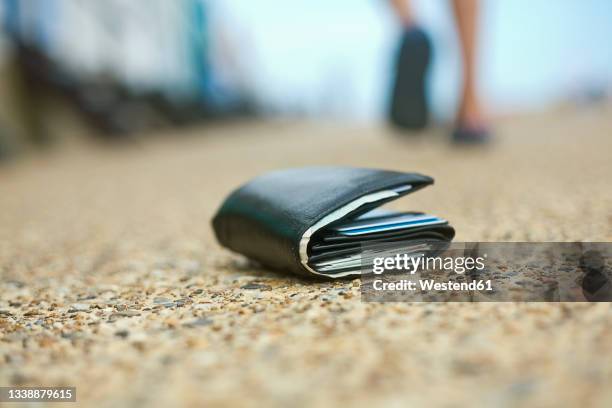 lost wallet lying on ground - cartera fotografías e imágenes de stock