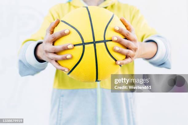 young woman holding yellow basketball - woman yellow basketball stock pictures, royalty-free photos & images