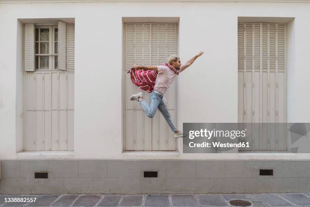 young man jumping over footpath as superhero - action hero foto e immagini stock