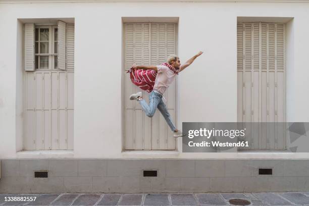young man jumping over footpath as superhero - action hero ストックフォトと画像