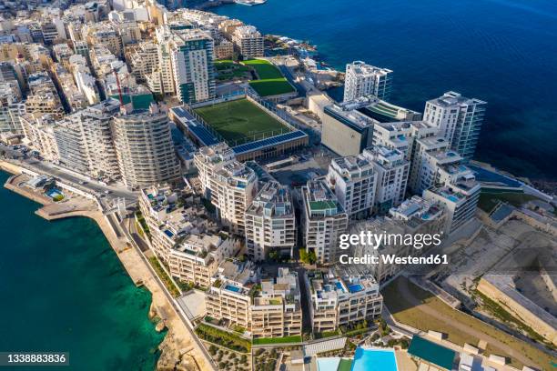 malta, central region, sliema, aerial view of soccer field, apartments and hotels of tigne point peninsula - maltese islands stockfoto's en -beelden