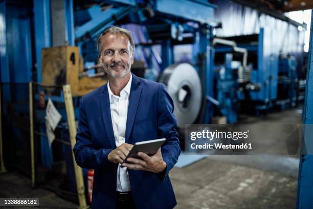 senior male inspector with digital tablet at steel mill - veste homme photos et images de collection