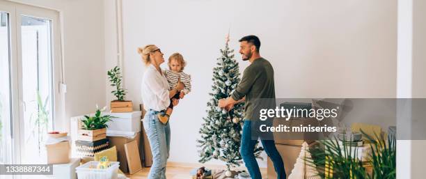 moving in: happy family decorating home for christmas - homeowners decorate their houses for christmas stockfoto's en -beelden