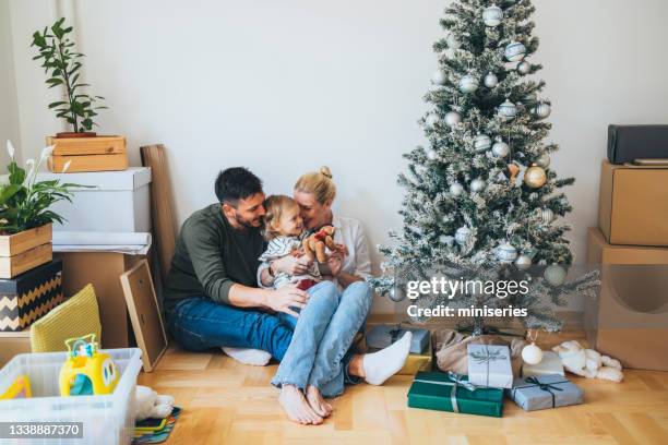 moving in: happy family decorating home for christmas - homeowners decorate their houses for christmas stockfoto's en -beelden