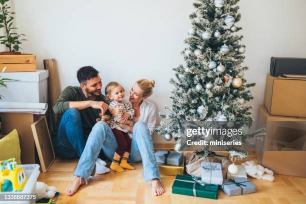 moving in: happy family decorating home for christmas - homeowners decorate their houses for christmas stockfoto's en -beelden