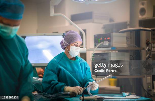 doctor working with colleague in operating room - laparoscopic surgery stock pictures, royalty-free photos & images