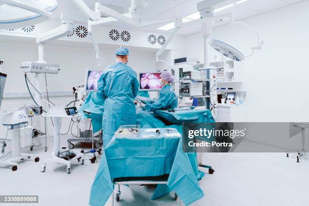 doctors performing surgery on patient in hospital - laparoscopy stock pictures, royalty-free photos & images