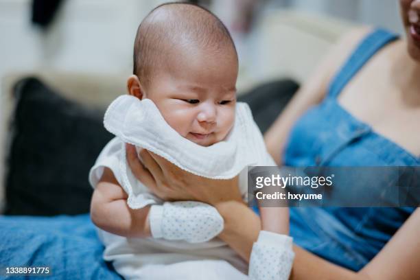 asiatische mutter rülpst baby nach der fütterung - burping stock-fotos und bilder