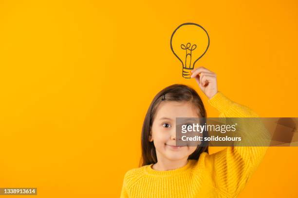 fille tenant une ampoule sur la tête - ampoule dessin photos et images de collection