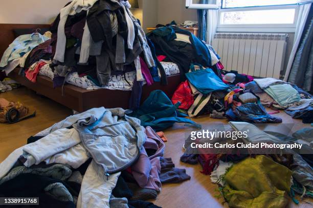 clothes and other objects scattered on floor and bed - traje completo imagens e fotografias de stock