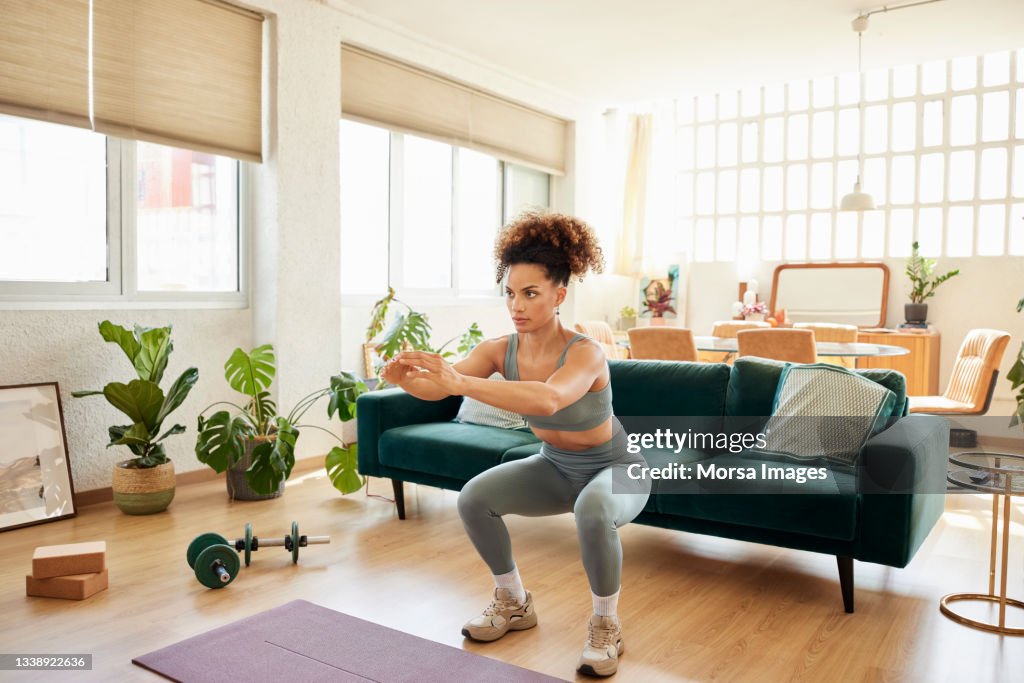 Young Fit Woman Doing Squats In Living Room
