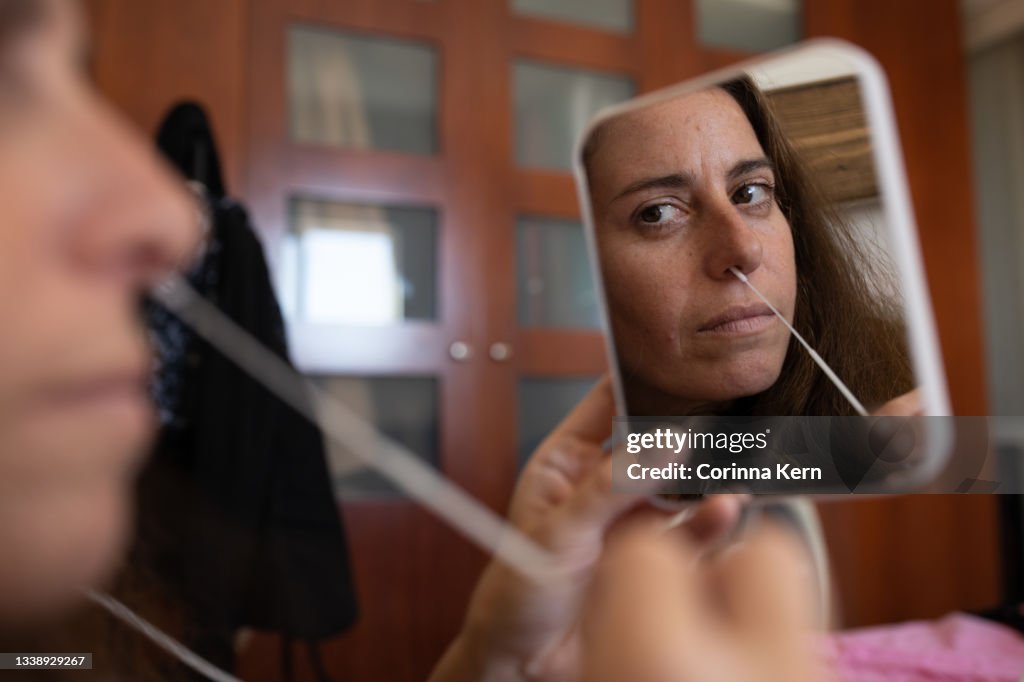 Woman performing a Covid-19 Antigen self-test at home