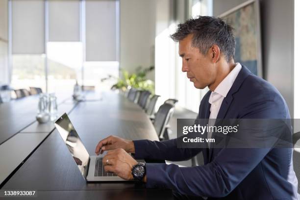 japanese-american businessman working on a laptop - laptop side view stock pictures, royalty-free photos & images