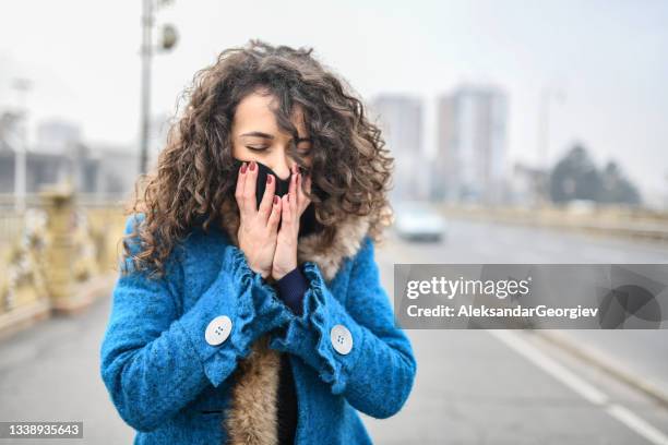 female struggling with bad air pollution while walking through city - smog city stock pictures, royalty-free photos & images