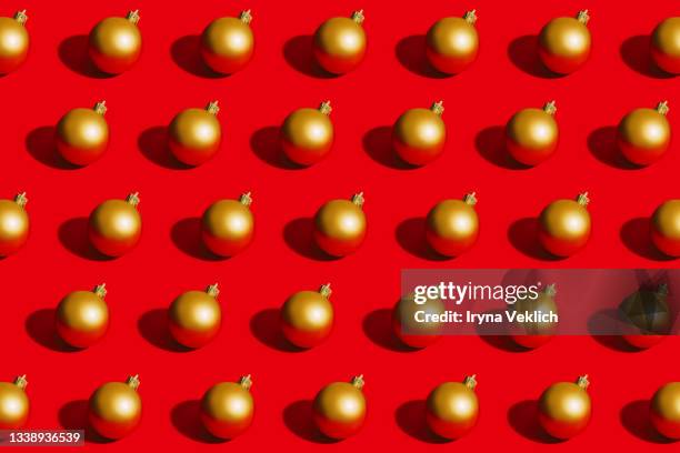 golden christmas ball on red color background. - glitter ball stock-fotos und bilder