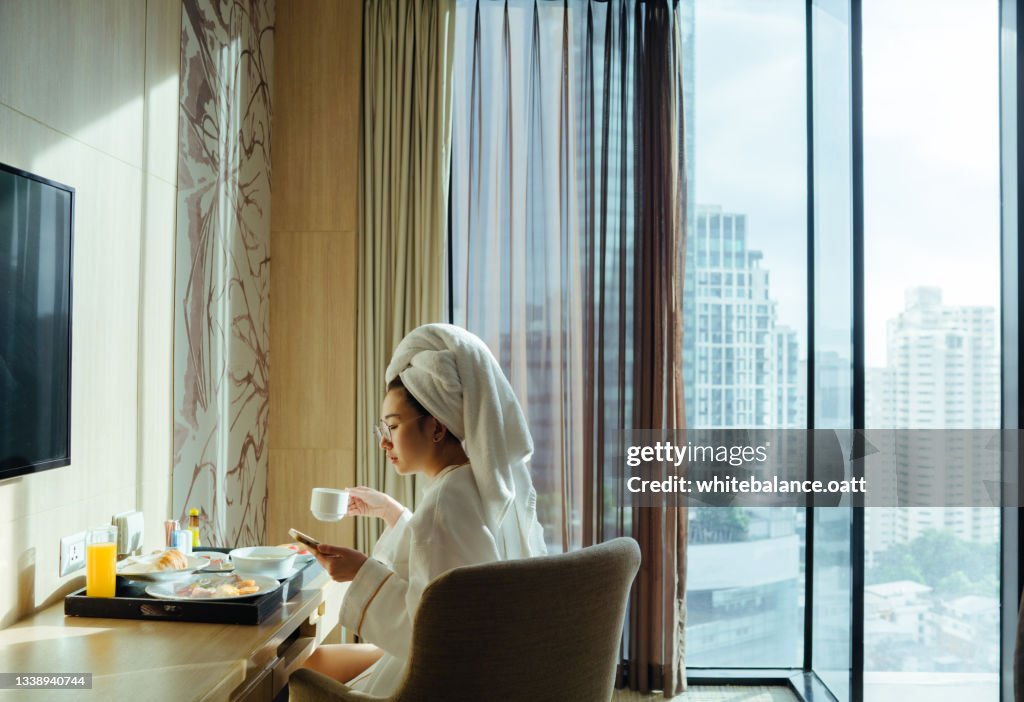 Lady eating breakfast in the hotel room