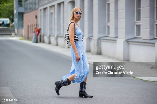 Cheyenne Tulsa is seen wearing blue dress, cowboy boots, bag with zebra print, blue sunglasses during Fashion Week Berlin on September 07, 2021 in...