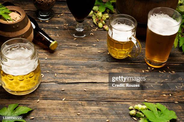 kaltes bier mit schaum auf einem holztisch - hopfen malz stock-fotos und bilder