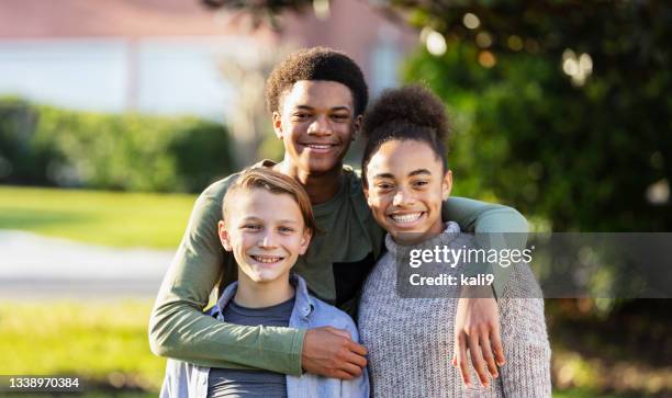 tres niños multiétnicos en una familia mixta - stepfamily fotografías e imágenes de stock