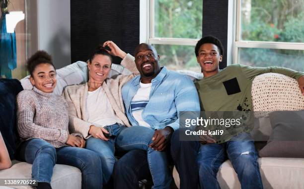 blended family sitting on couch watching tv - blended family stockfoto's en -beelden