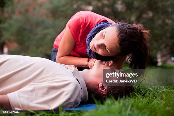 first aid - look, listen and feel for breathing. - ehbo stockfoto's en -beelden