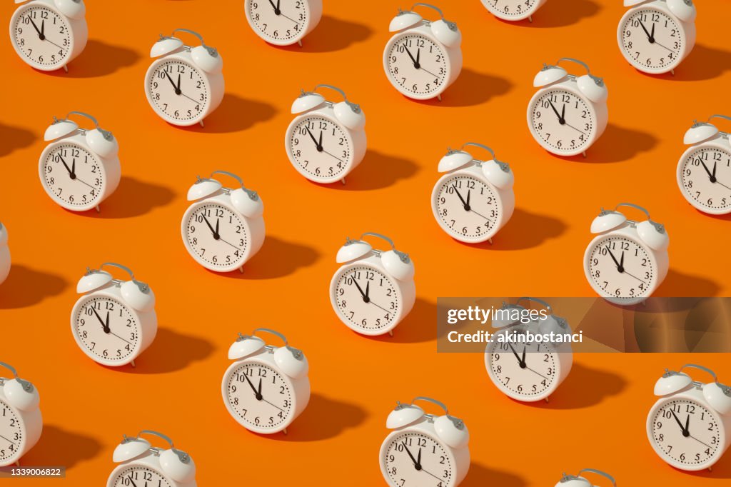Wecker auf orangefarbenem Hintergrund