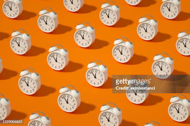 alarm clock on orange color background - 3d illustration stockfoto's en -beelden