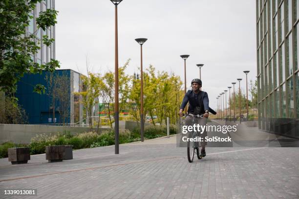 hombre de negocios que viaja en bicicleta al trabajo - ciclista fotografías e imágenes de stock