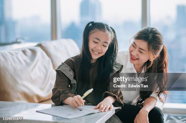 asian chinese young family mother daughter enjoying bonding time doing homework  at home during weekend in living room apartment - malaysia beautiful girl 個照片及圖片檔