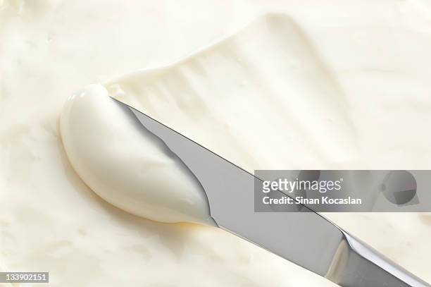 a knife swiping into some cream cheese - tafelmes stockfoto's en -beelden