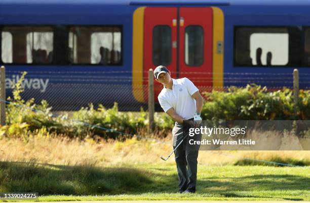 Tom Holland chips on to the 9th as a train is seen in the background during the Pro-Am event prior to The BMW PGA Championship at Wentworth Golf Club...