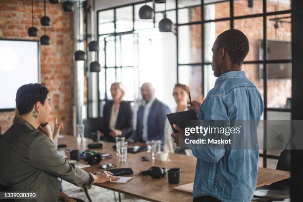 male hacker presenting ideas with colleagues at creative office - storytelling recomendation stock-fotos und bilder