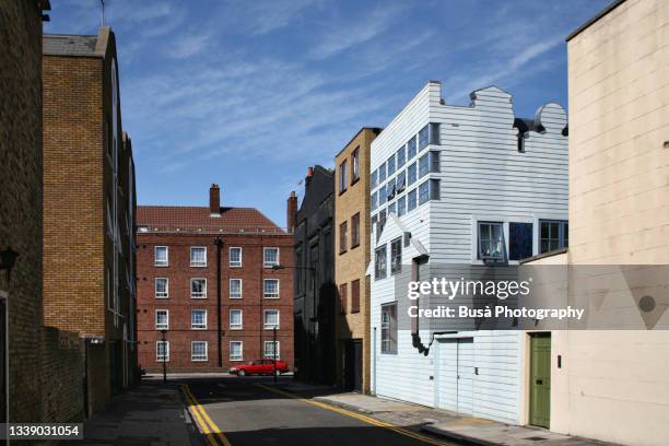 red car driving in empty street in dalston, east london, in the london borough of hackney - east london bildbanksfoton och bilder