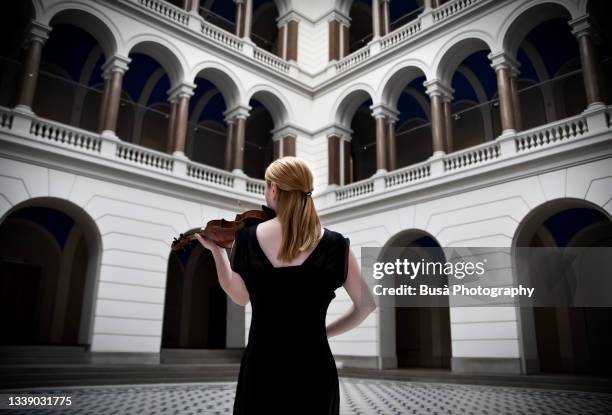 young woman playing the violin - atrium stock pictures, royalty-free photos & images