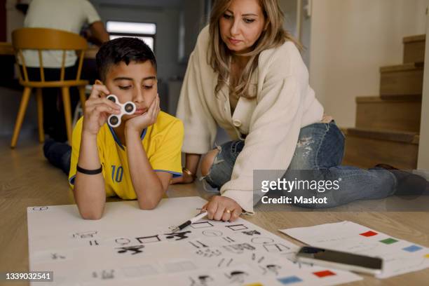 mother teaching son while sitting at home - disabilitycollection ストックフォトと画像