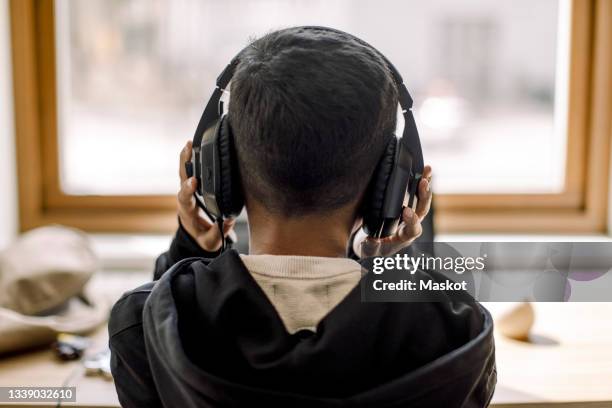 rear view of autistic boy with headphones at home - adhd child imagens e fotografias de stock