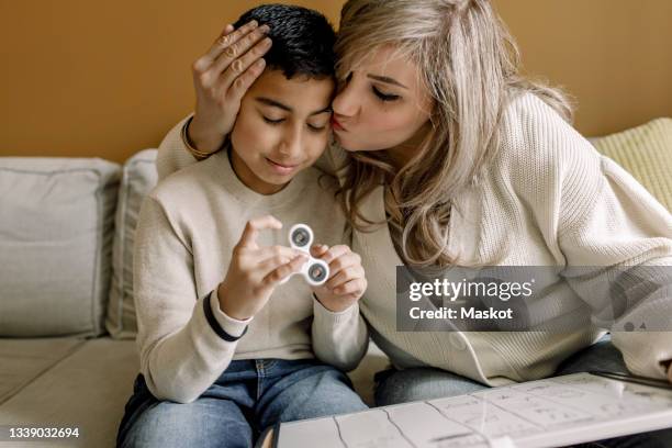 mother kissing son while teaching at home - disabilitycollection fotografías e imágenes de stock