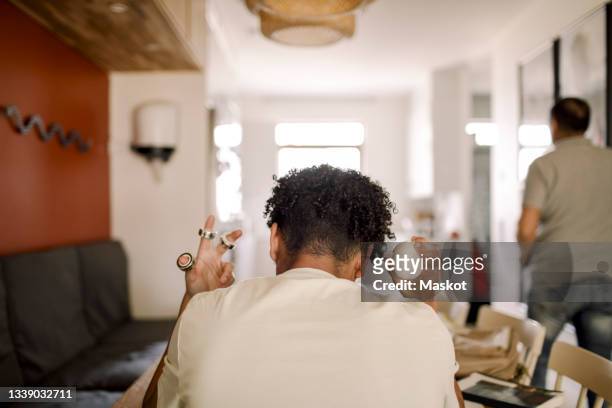 rear view of female teenager sitting at home - autismo foto e immagini stock