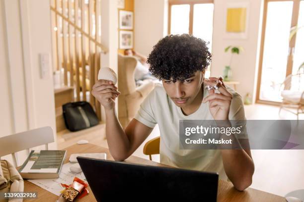 teenager boy using laptop while sitting at home - adhs stock pictures, royalty-free photos & images