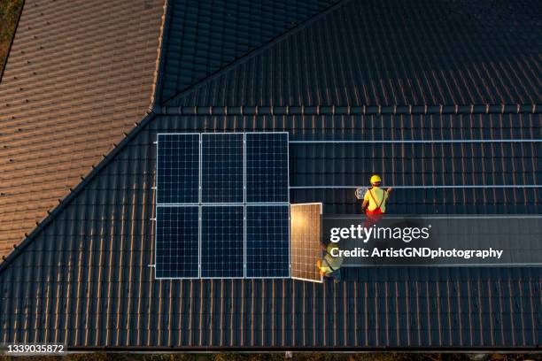 installazione di pannelli solari su un tetto di una casa. - pannello solare foto e immagini stock