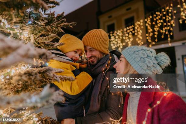 celebrating christmas outdoors with our son - family christmas stock pictures, royalty-free photos & images