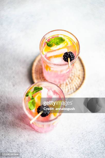 overhead view of two pink blackberry and lemon cocktails on a table - coaster stock pictures, royalty-free photos & images