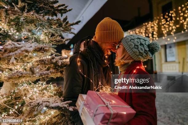 romantisches paar mit weihnachtsgeschenken im freien - couple in evening clothes stock-fotos und bilder