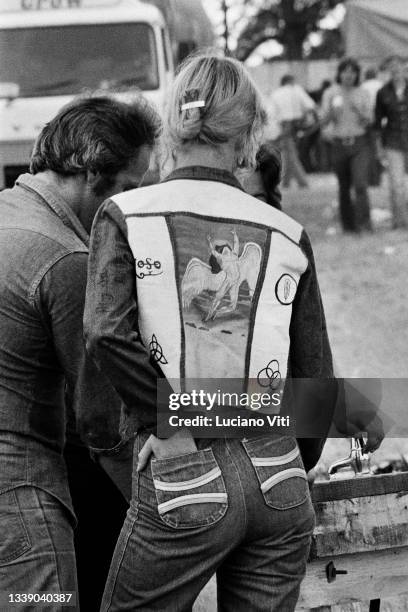 Man and woman in the audience at Led Zeppelin's Knebworth concert wearing double denim with her jacket featuring Led Zeppelin logos, United Kingdom,...