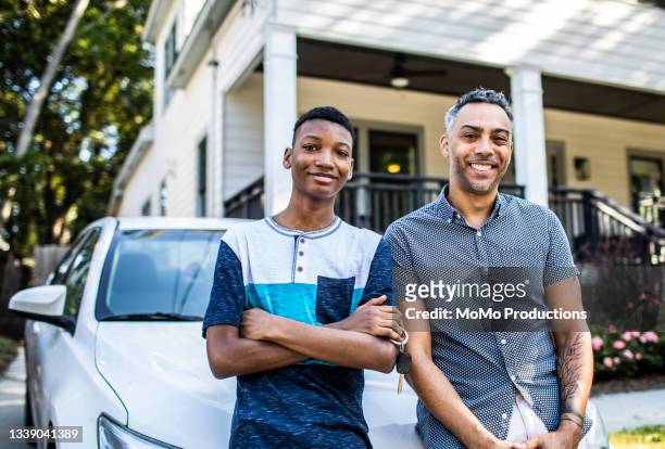 portrait of young man and his father in front of his first car - car ownership fotografías e imágenes de stock
